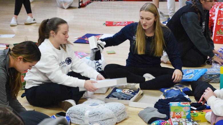 Penn State Abington student athletes wrap gifts for a family in need
