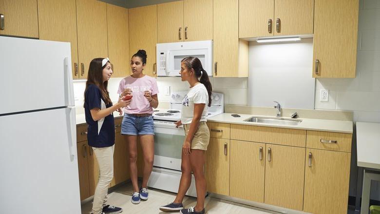 three students talking in kitchen at Lions Gate